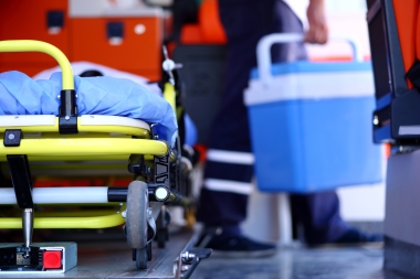 person holding cooler next to stretcher