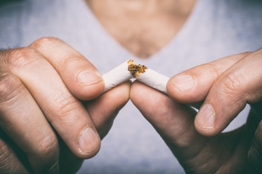 hands breaking cigarette in half