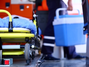 person holding cooler next to stretcher