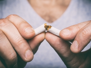 hands breaking cigarette in half